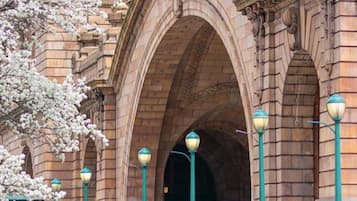 Un bâtiment historique doté d’entrées en arc de cercle et de lampadaires de style traditionnel.