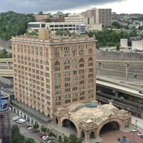 A multi-story building with a classical architectural style, featuring a central courtyard with arches and a dome.