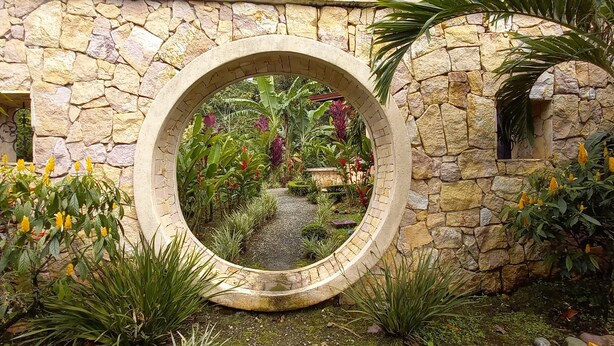Un arco de piedra con vistas a un jardín.