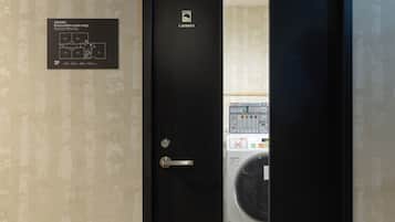 A door with a laundry machine inside, a sign indicating an evacuation route map, and a wall with a patterned design.