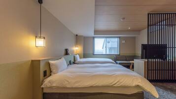A hotel room with a large bed, bedside lamps, a desk, and a TV.