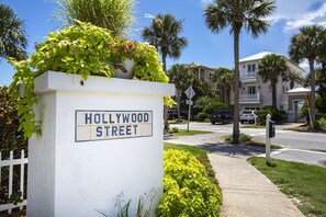 Un panneau de signalisation indiquant la rue Hollywood, avec un poteau blanc et des lettres bleues.