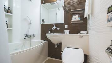 A modern bathroom with a bathtub, sink, and toilet.