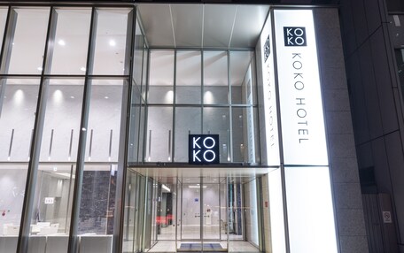 A modern hotel entrance with glass doors and a clear view into the lobby.