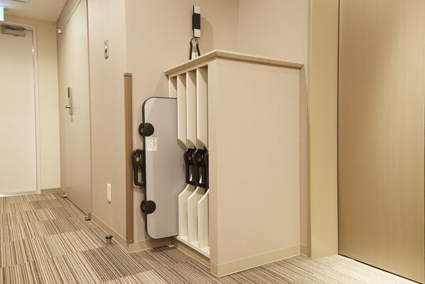 A hotel corridor with a wall-mounted coffee machine and a coat rack.