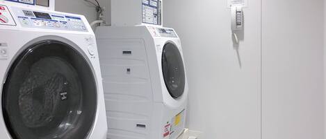 Une buanderie équipée de deux machines à laver à chargement frontal et d’un sèche-linge.