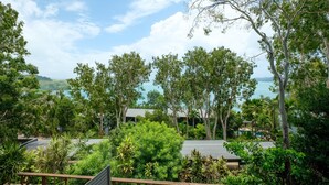 A resort with multiple buildings surrounded by lush greenery and a view of the sea. - Sunset Waters 03 - Hamilton Island (Whitsundays)
