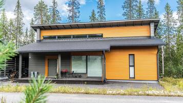 Een modern huis met twee verdiepingen, een overdekte veranda, grote ramen en een garage.