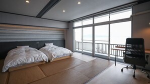 Ein Hotelzimmer mit Bett, Schreibtisch und einem großen Fenster mit Blick.