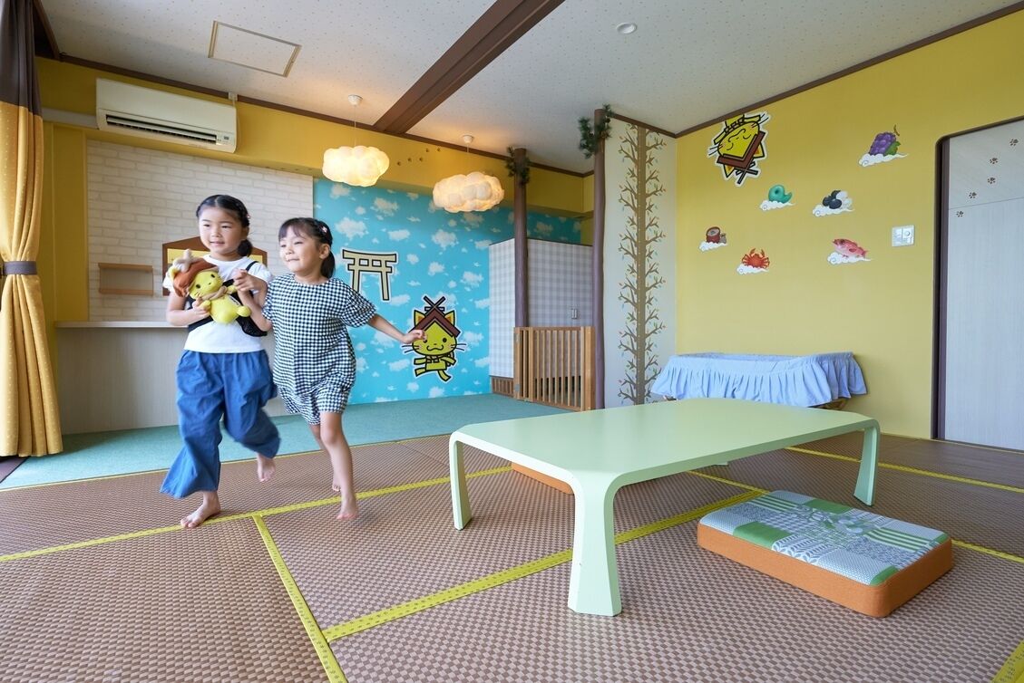 Una habitación con suelo de tatami, una mesa baja y un cojín.