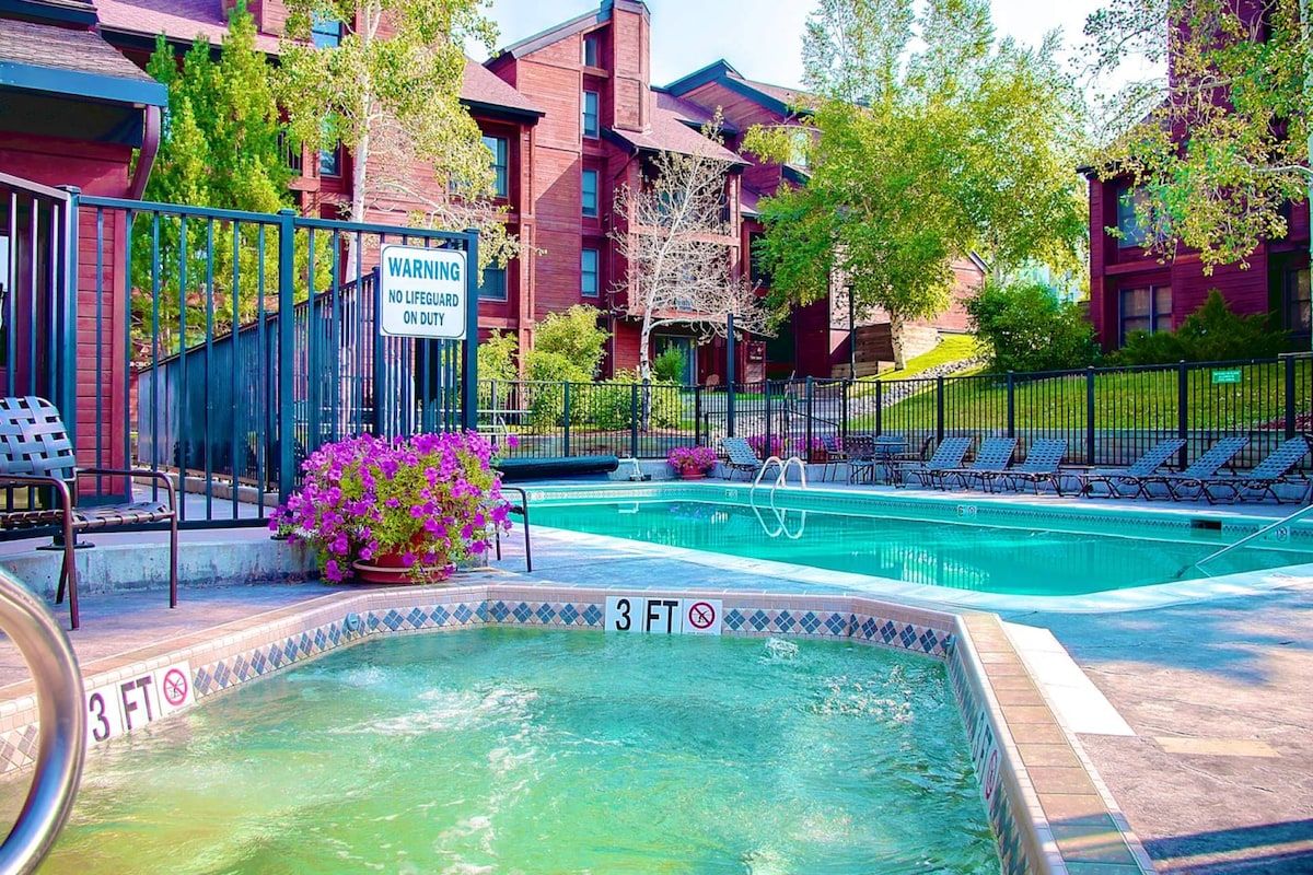 A swimming pool with a 3 FT depth limit, surrounded by a fence, with a warning sign and lounge chairs.
