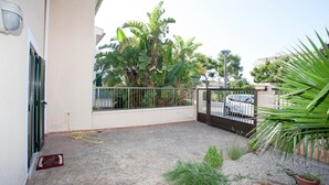A balcony with a concrete floor, a potted plant, and a metal gate. - Family House in Port of Alcudia | Pool, Terrace & 11 min Walk to Beach (Puerto de Alcudia)