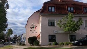 Hotel Schenk, con un letrero que indica un restaurante y un parque cerca.