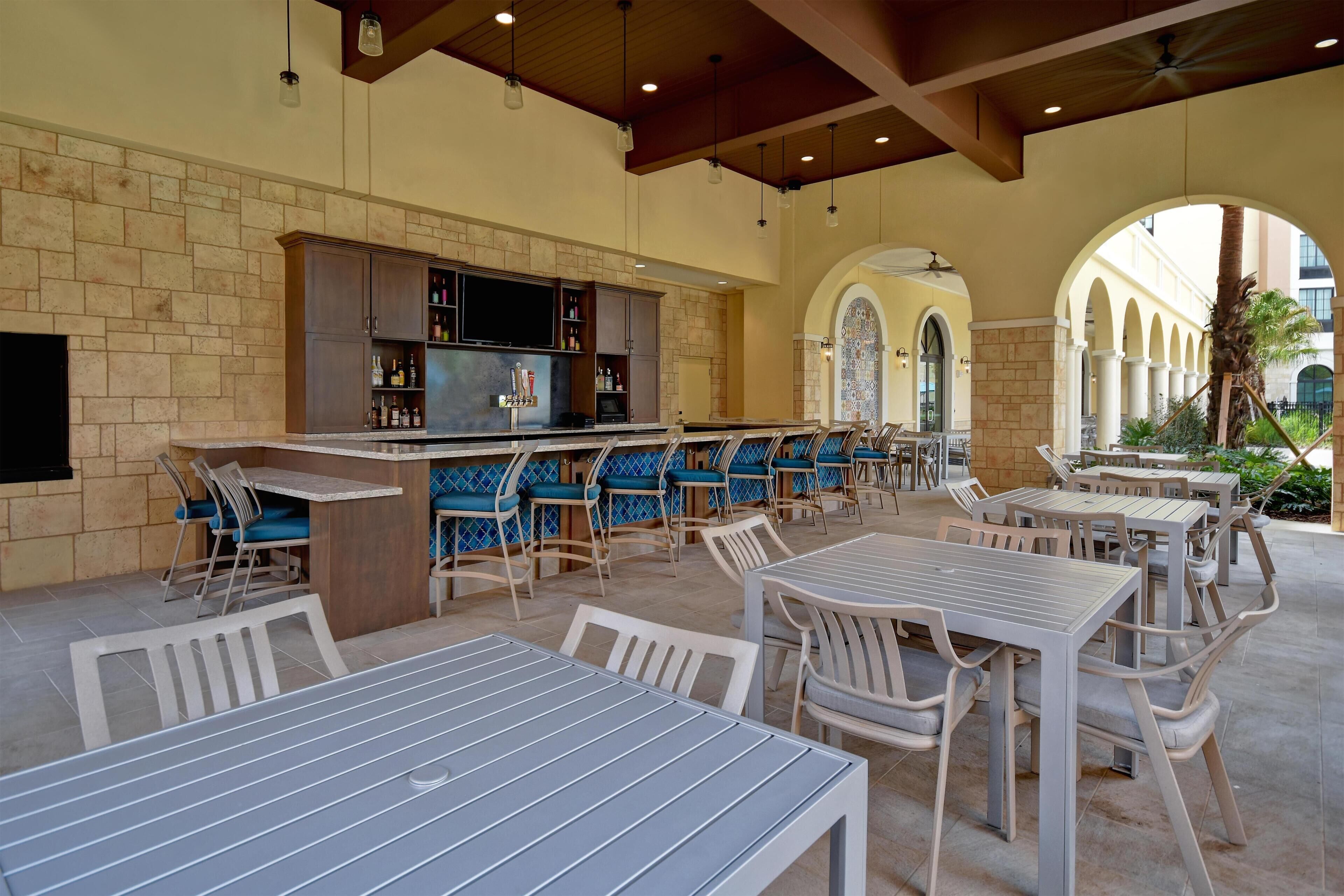 An outdoor patio area with seating and a bar.