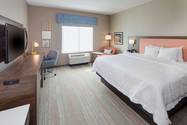 A hotel room with a large bed, a desk with a computer, a chair, a TV, and a window with a view. - Hampton Inn by Hilton Smithfield Selma (Smithfield)