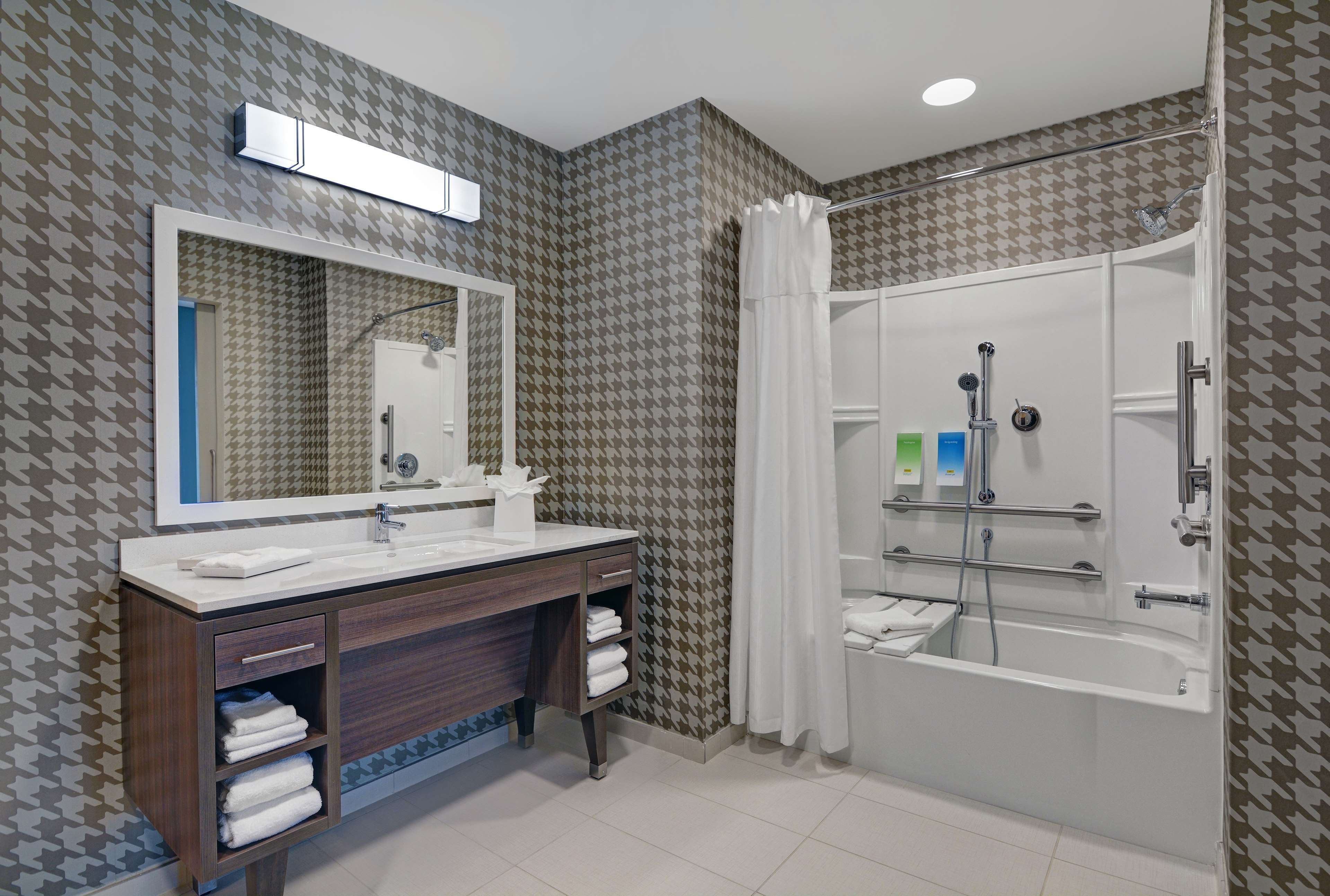 Ein Badezimmer mit Dusche, Waschbecken und Spiegel.