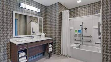 Ein Badezimmer mit Dusche, Waschbecken und Spiegel.