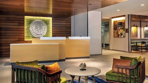 A reception area with a wooden ceiling, a reception desk, and seating with cushions. - Fairfield Inn & Suites by Marriott Harrisburg West/Mechanicsburg (Mechanicsburg)