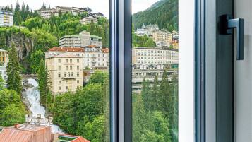 Una ventana con vistas a un paisaje urbano, con edificios y una cascada.