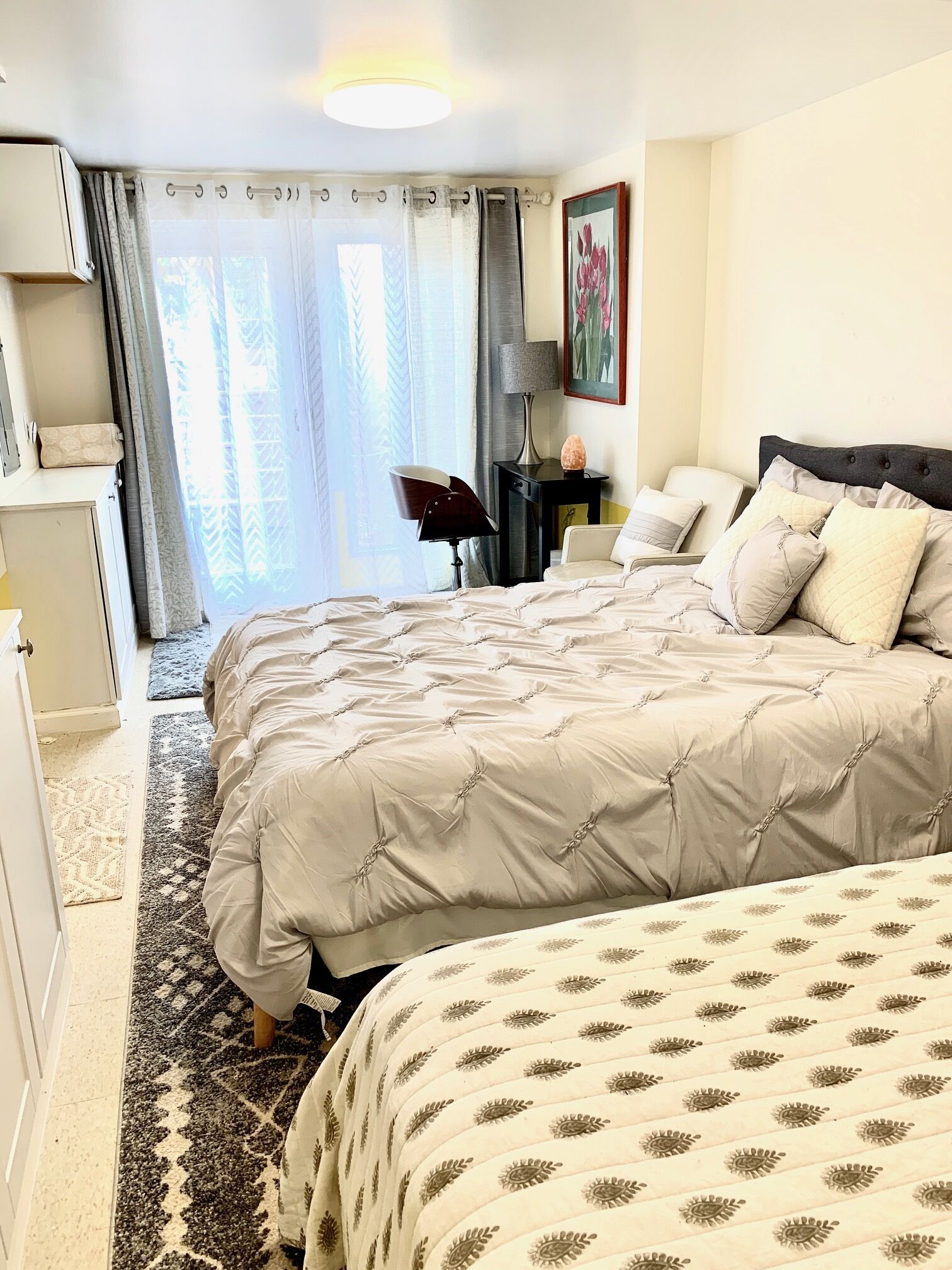 Une chambre d’hôtel avec un grand lit, un bureau, une chaise et une fenêtre avec des rideaux.