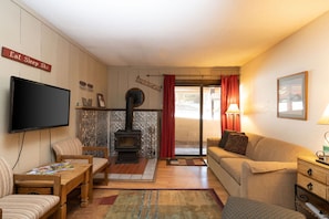 Una sala de estar acogedora con chimenea, televisor, sofá y comedor.