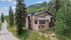 A two-story building with a sign reading "Angelhaus" and a mountain backdrop. - Value Condo, Hot Tub and Pool, Walk to Trails! (Durango)