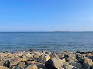 Una riba rocosa amb vista al mar i illes llunyanes.