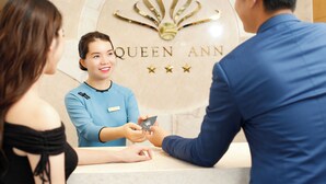 Una mesa de recepción con un letrero que dice "QUEEN ANN" y un emblema decorativo.