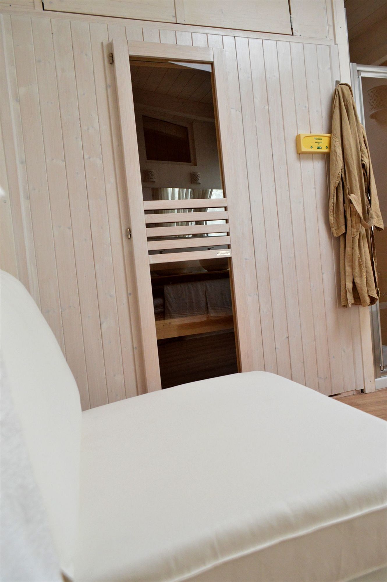 Una habitación con una cama, un armario de madera y un perchero.