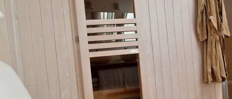 Una habitación con una cama, un armario de madera y un perchero.