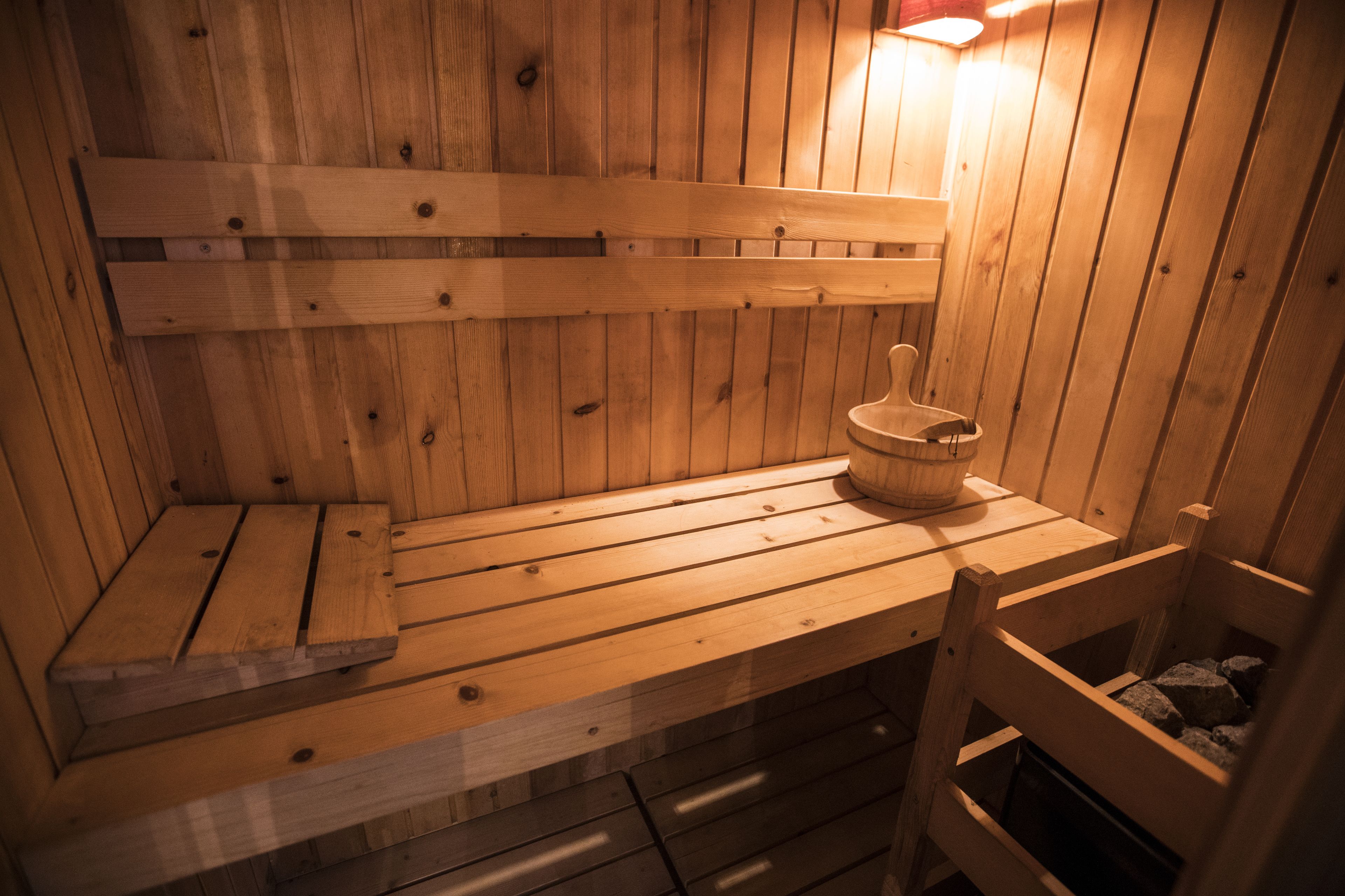 Un sauna en bois avec des bancs et un seau en bois.