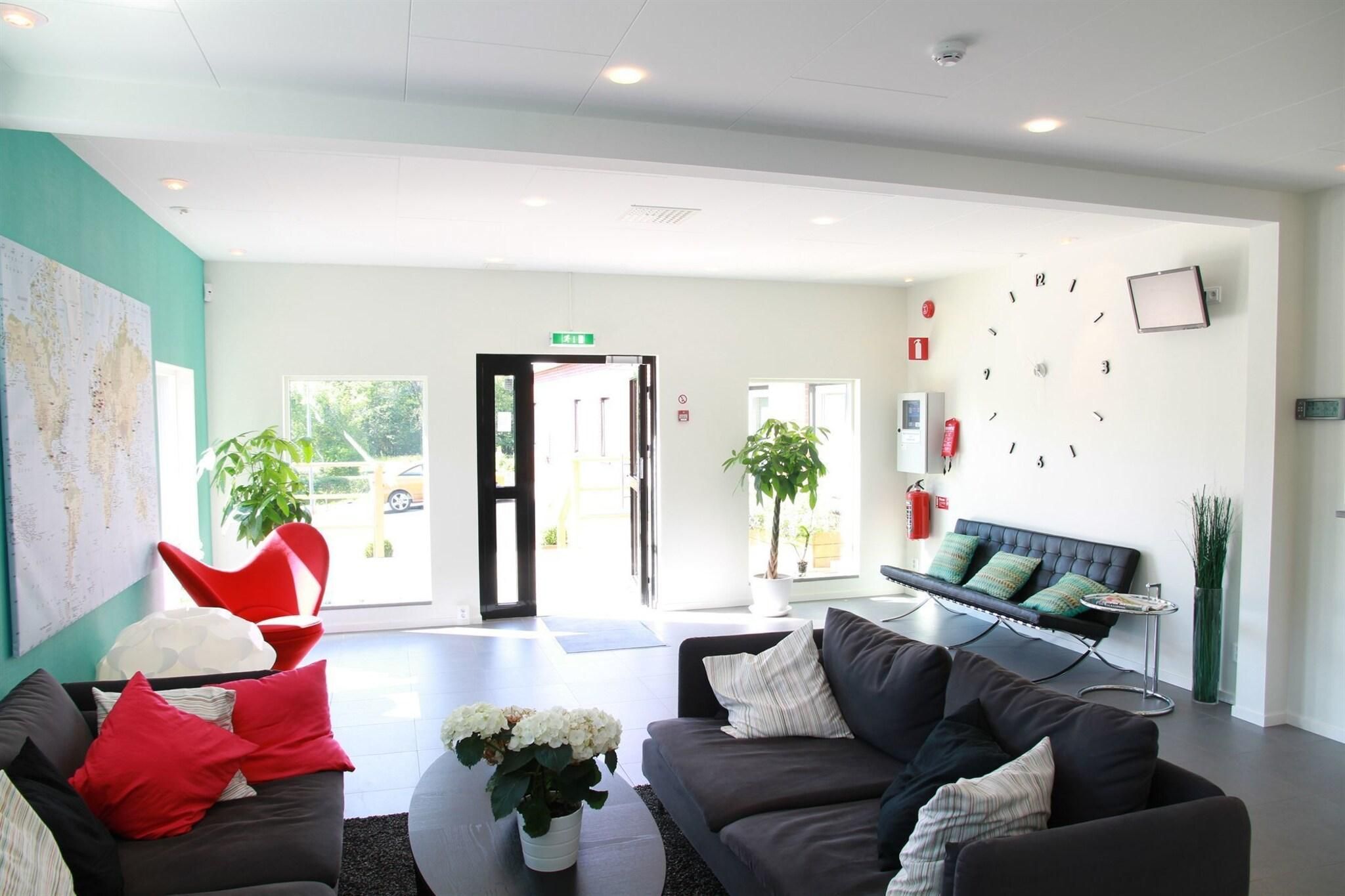 A modern reception area with a sofa, chairs, a coffee table, and a map on the wall.