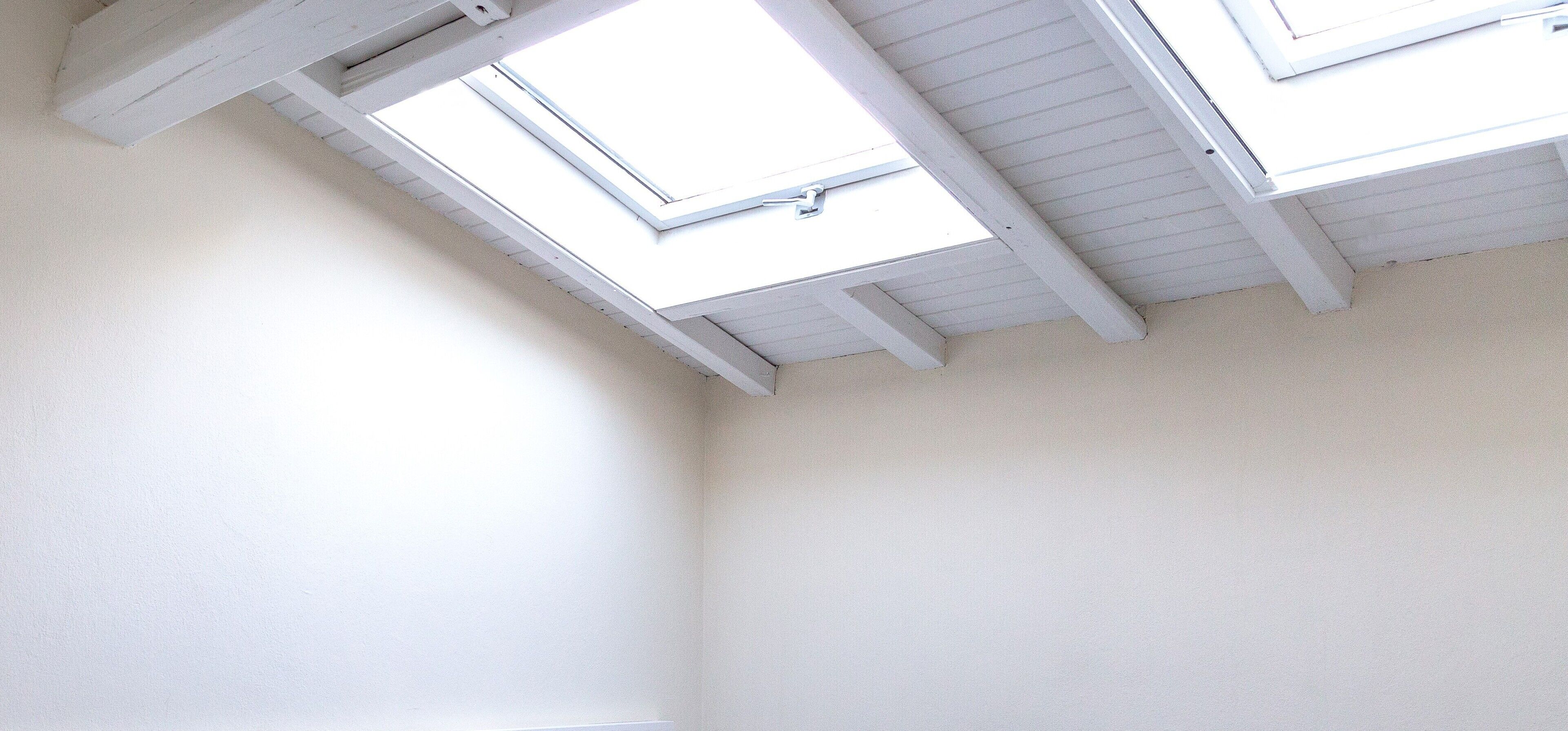 Una stanza con soffitto spiovente e lucernari.