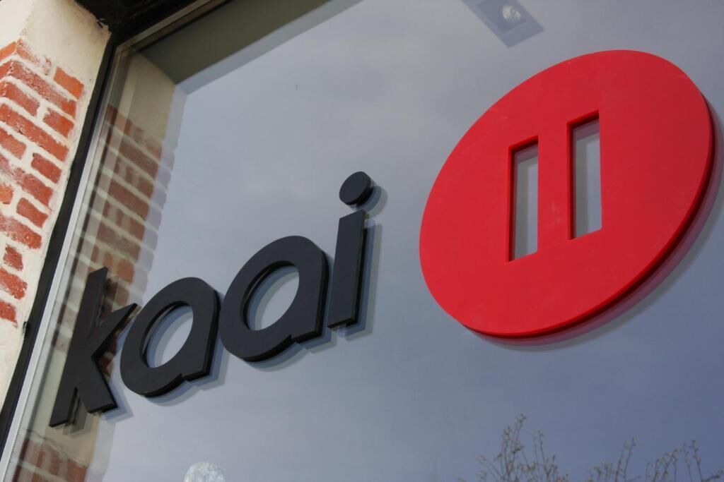 A building facade with the signage "kaai" and a red circular logo.
