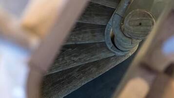 Gros plan d’un escalier en colimaçon avec une main courante en bois et une balustrade en métal.
