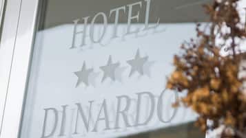Un letrero de hotel con el nombre 'HOTEL DINARDO' y tres estrellas.