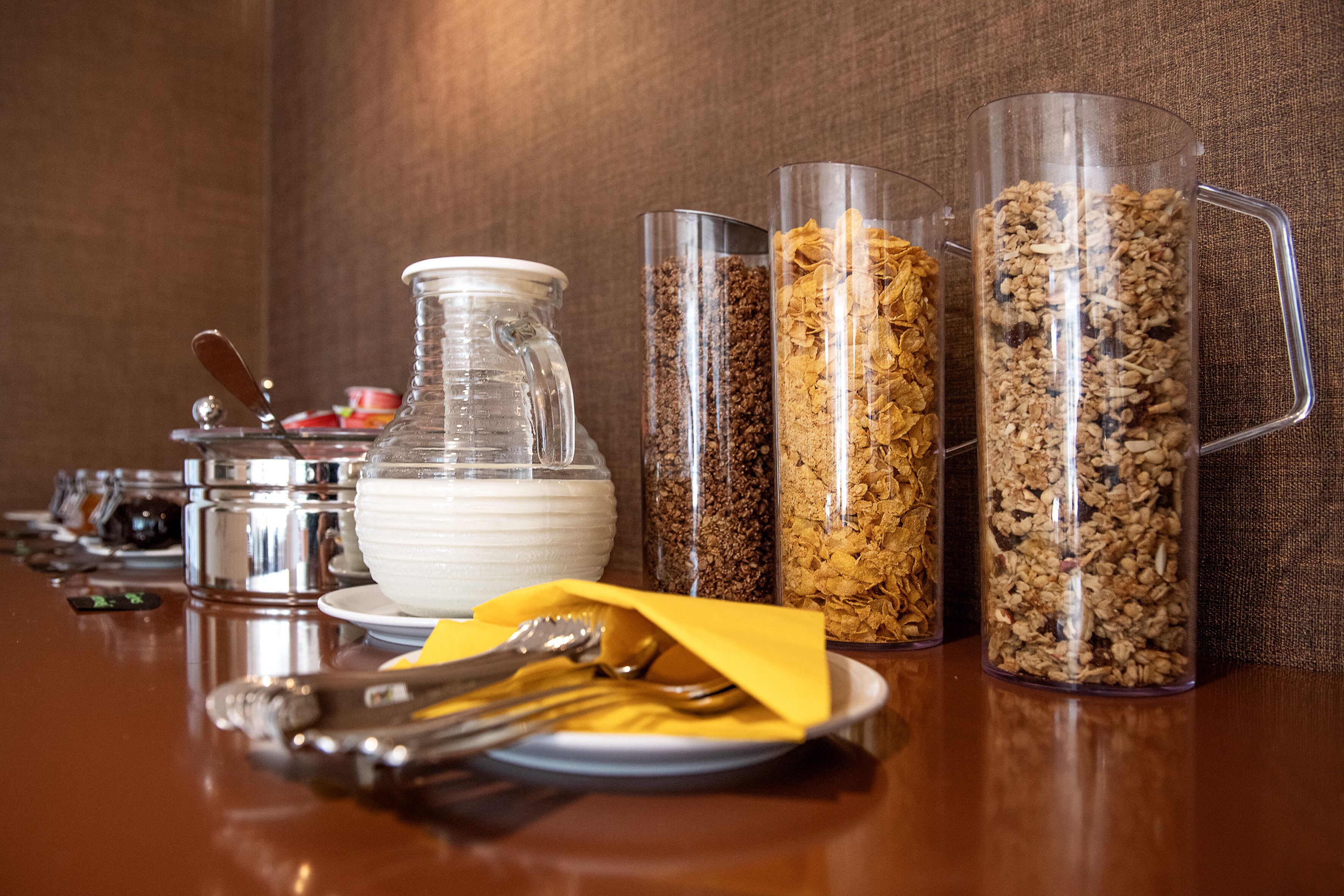 A breakfast buffet with various food items and utensils.