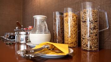 Un bufé de desayuno con diversos alimentos y utensilios.