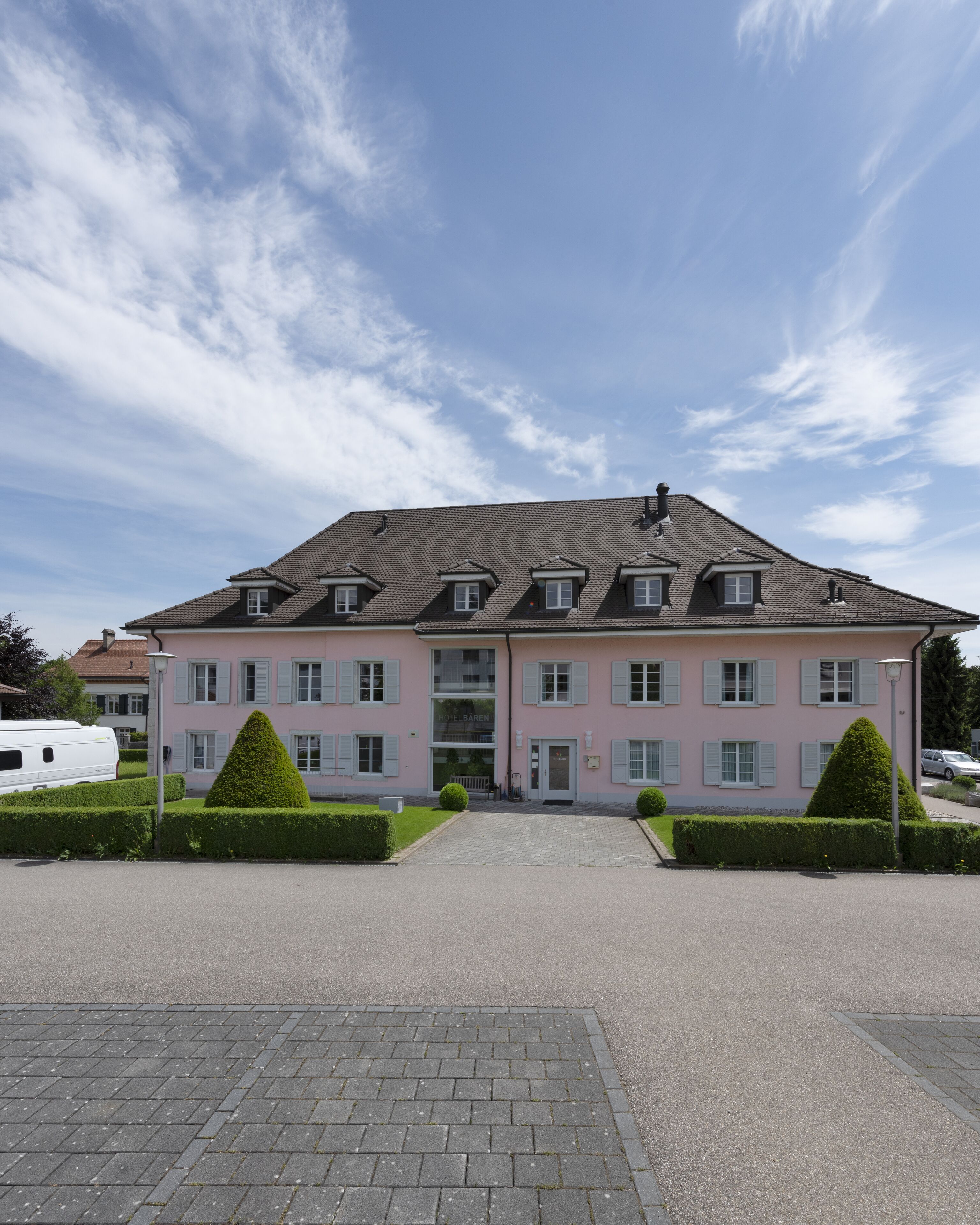 A large, pink building with a symmetrical facade, multiple windows, and a central entrance.