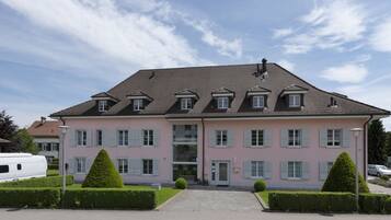 A large, pink building with a symmetrical facade, multiple windows, and a central entrance.