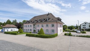 Un grand immeuble à étages, doté d’une façade symétrique, de nombreuses fenêtres et d’une entrée centrale.