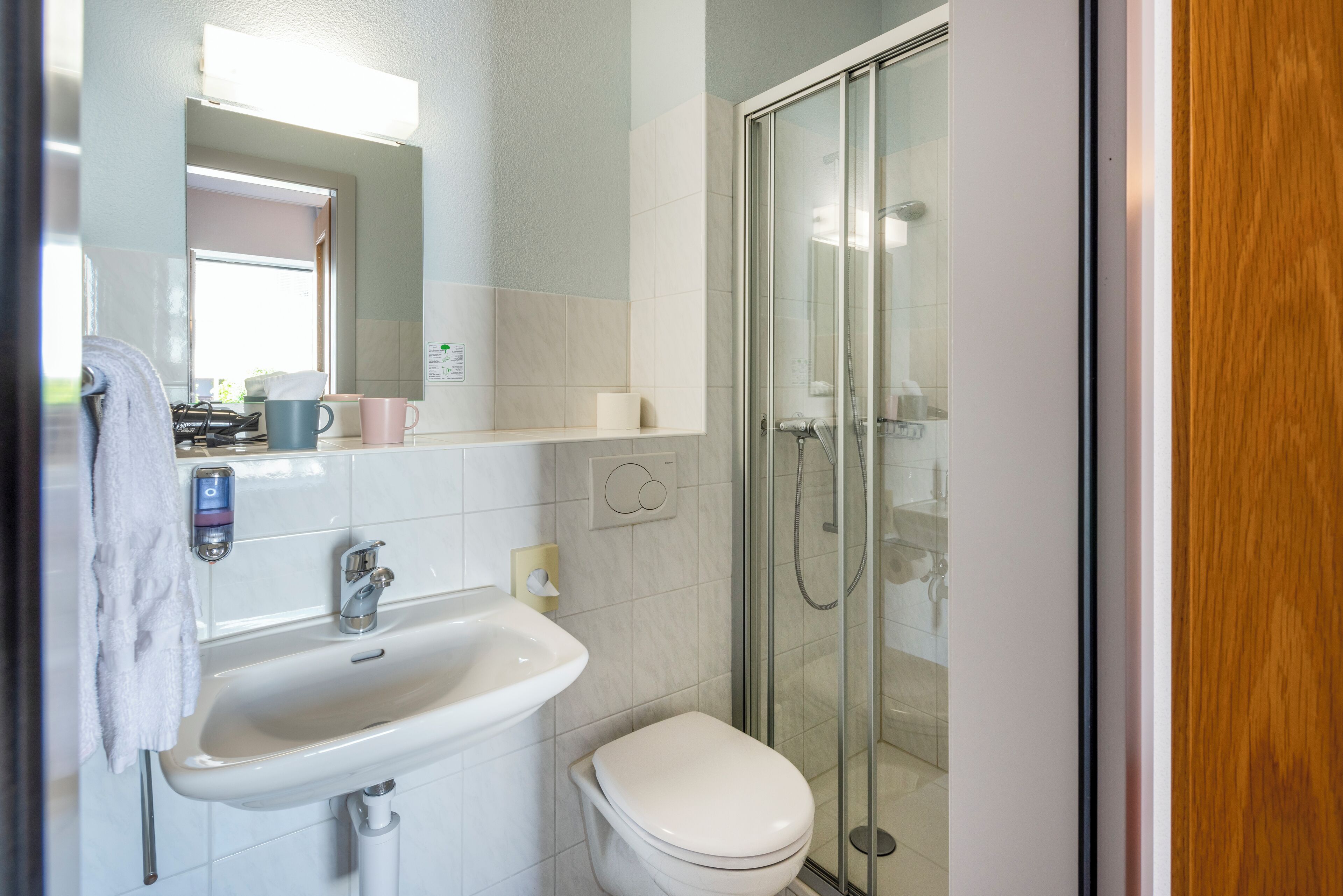 Un baño con lavamanos, inodoro y cabina de ducha de vidrio.