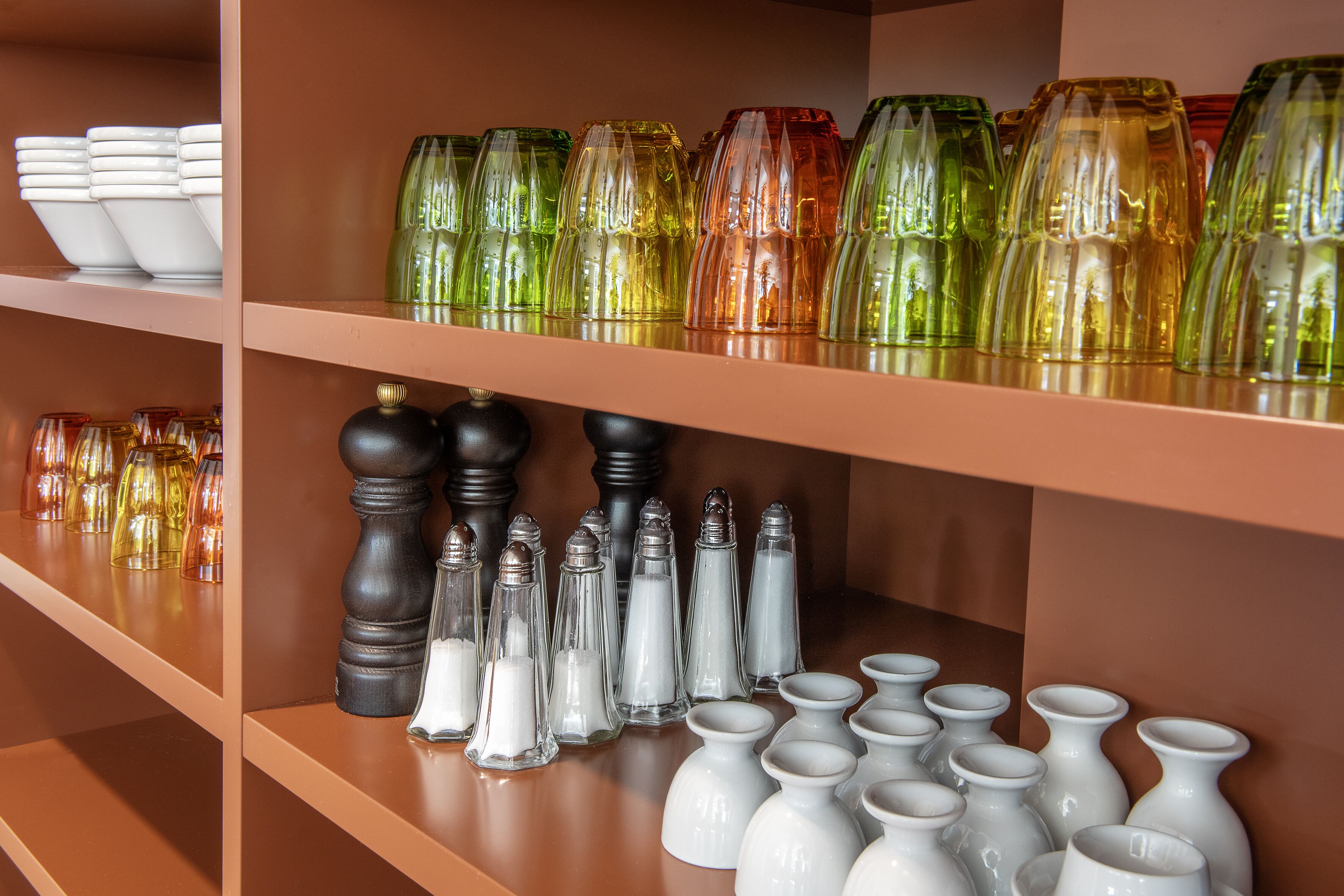 Étagères présentant divers objets en verre et en céramique.