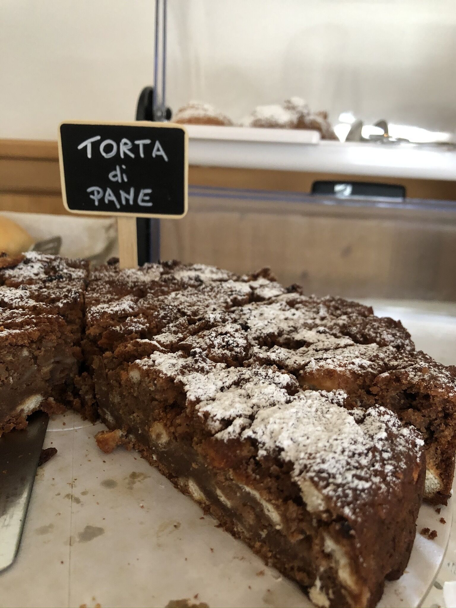 A slice of torta di pane on a plate with a sign indicating it is a type of bread.