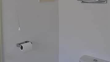 A bathroom with a toilet, a towel rack, and a toilet paper holder.