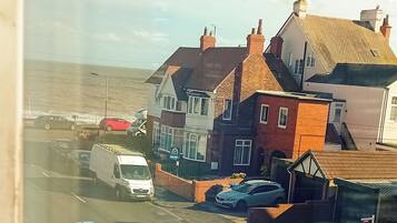A coastal street with parked cars and buildings.