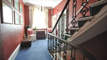 A staircase with ornate black railings and a blue carpet.