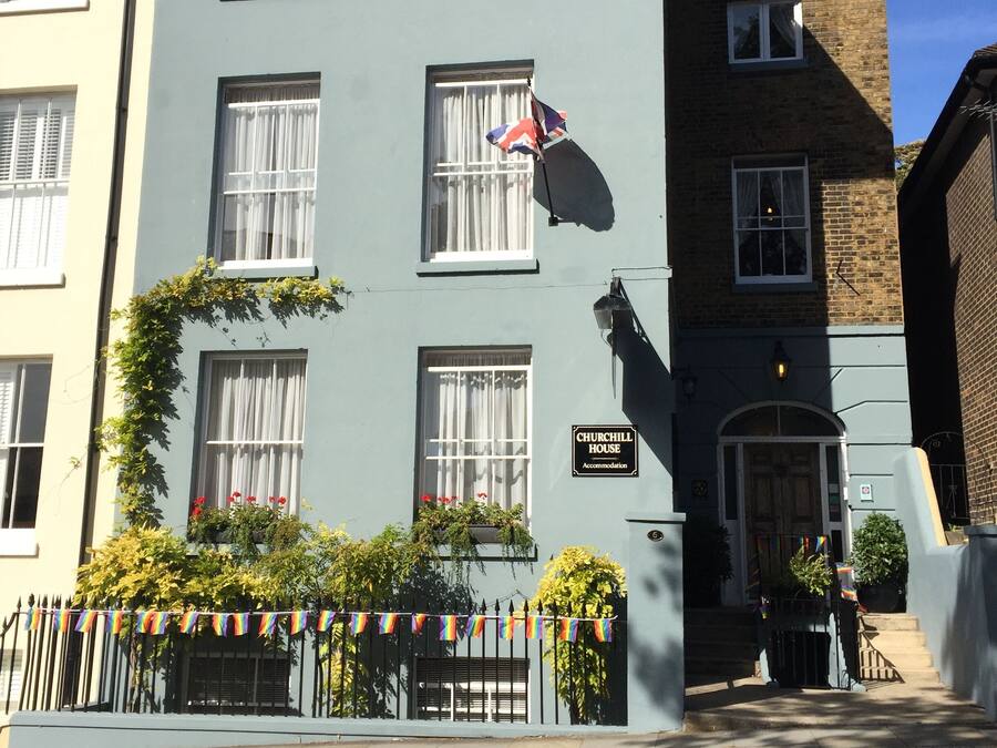 Un edificio de dos pisos con un letrero que dice 'CHURCHILL HOUSE Accommodation'.
