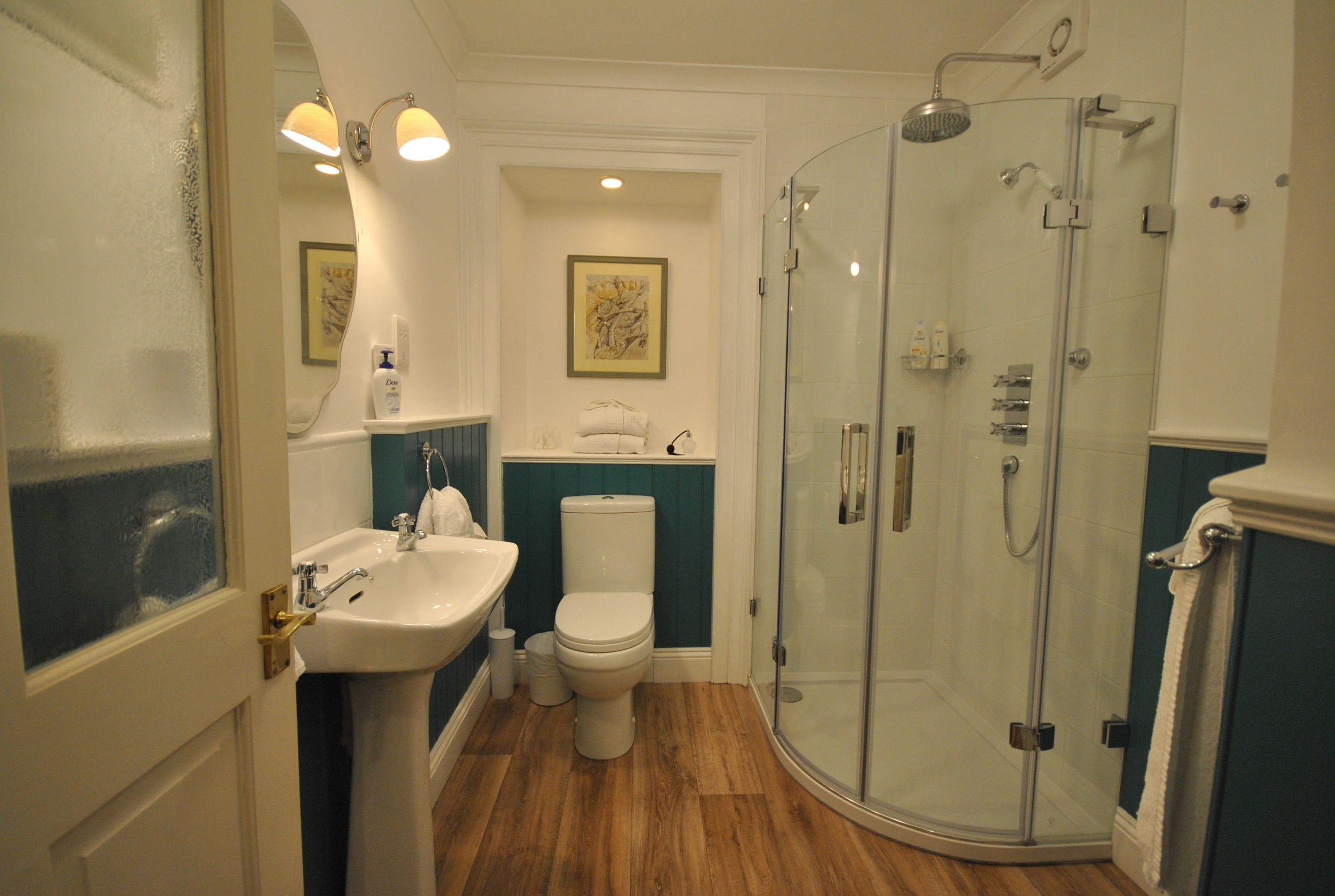 A bathroom with a sink, toilet, and glass-enclosed shower.