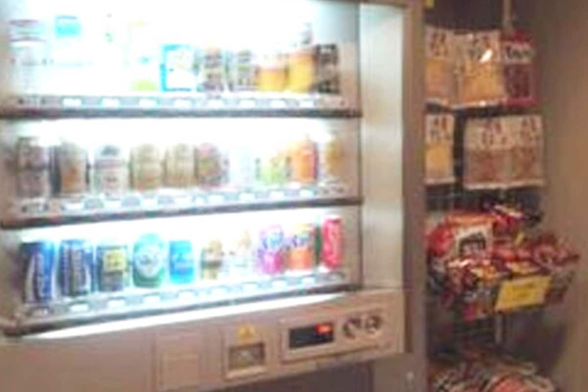 Máquina automática com diversos snacks e bebidas.